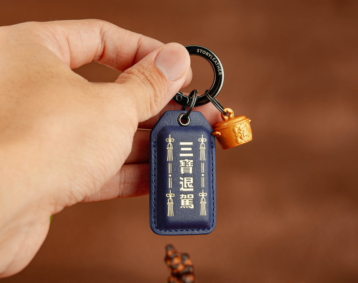 Safe Travels Amulet clipped as a keychain, held in hand