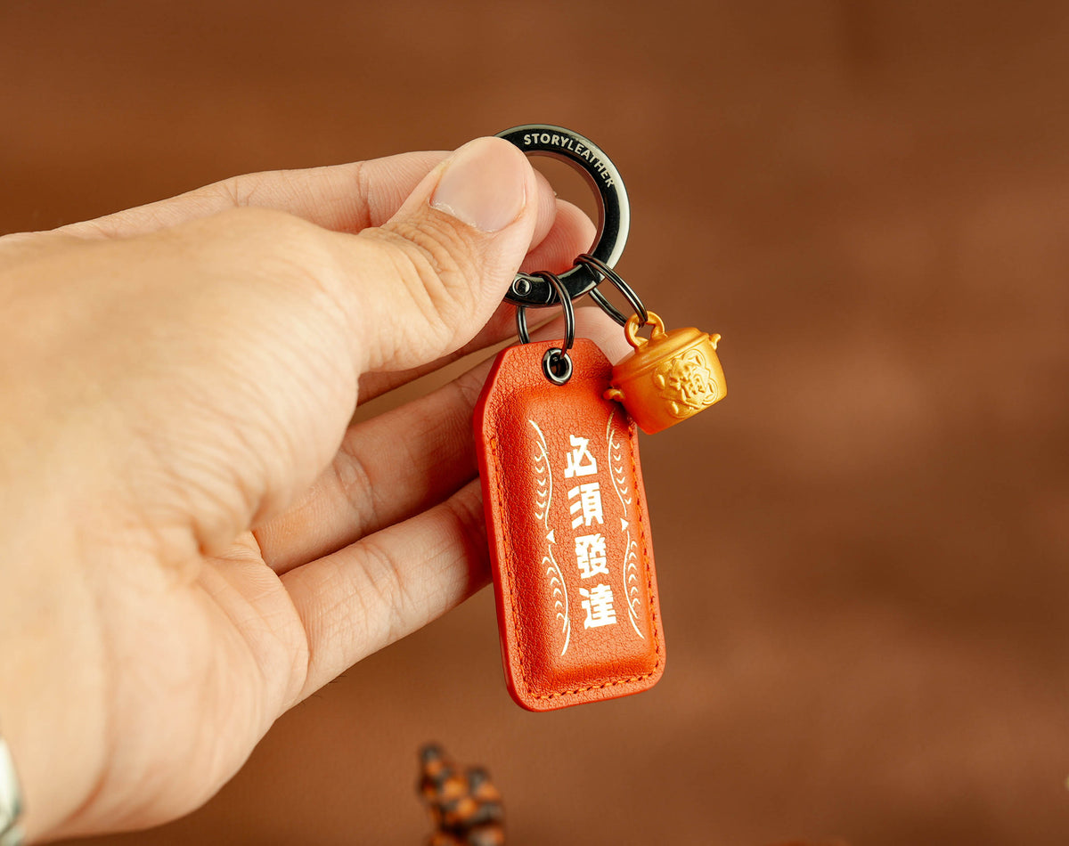 Career Breakthrough Amulet clipped as a keychain, held in hand