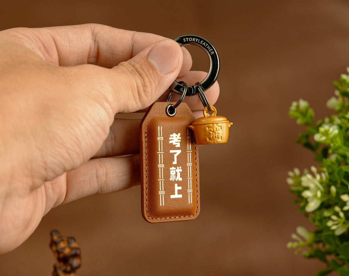 Ace the Exam Amulet clipped as a keychain, held in hand