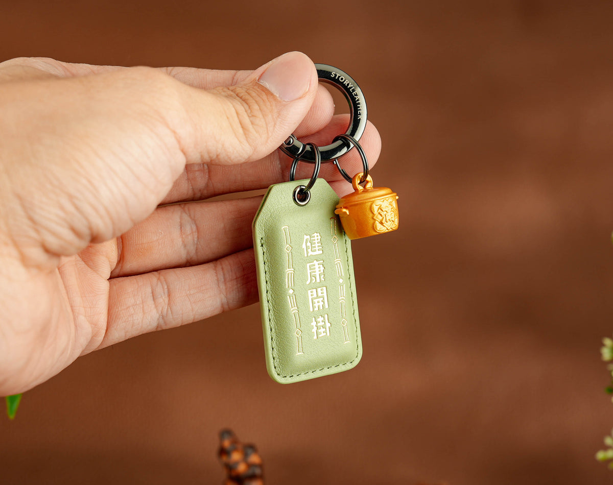 Health Level-Up Amulet clipped as a keychain, held in hand