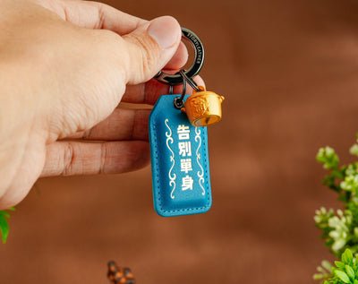 Goodbye Single Amulet lake blue clipped as a keychain, held in hand